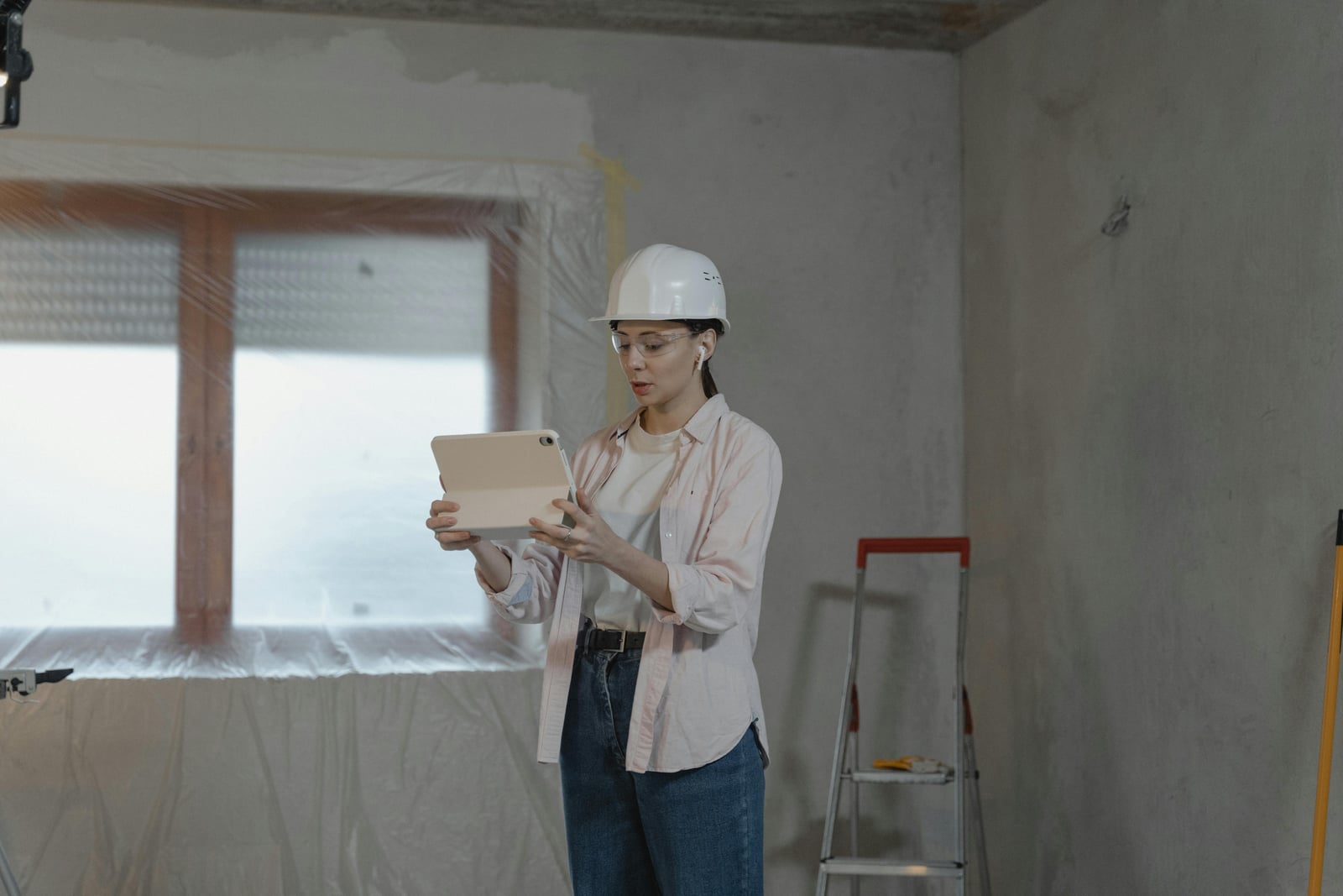 A woman in trades using her phone for work